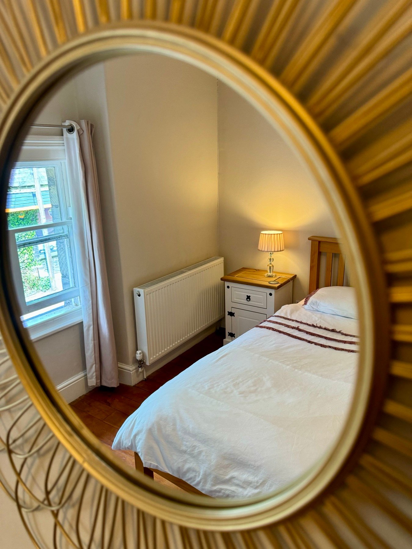 A quiet guest bedroom above Abbasi's, lamp-lit and made up for the night